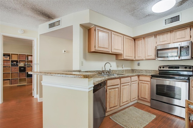 1280 S Alhambra Cir Unit 2206, Coral Gables, FL 33146 - kitchen with appliances with stainless steel finishes, wood finished floors, light brown cabinetry, a textured ceiling, and a peninsula