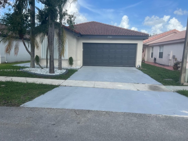 2383 SW 177th Ter, Miramar, FL 33029 - view of front facade with driveway, a garage, a tile roof, and stucco siding
