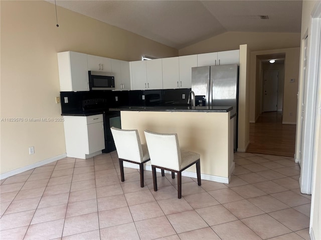 2383 SW 177th Ter, Miramar, FL 33029 - kitchen with black electric range oven, vaulted ceiling, dark countertops, stainless steel fridge with ice dispenser, and light tile patterned floors