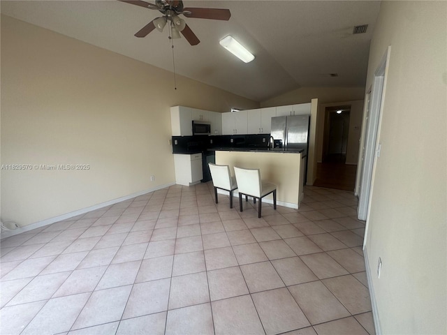 2383 SW 177th Ter, Miramar, FL 33029 - kitchen with stainless steel appliances, vaulted ceiling, white cabinetry, dark countertops, and a ceiling fan