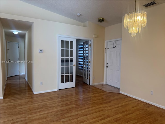 2383 SW 177th Ter, Miramar, FL 33029 - empty room featuring a chandelier, light wood-style flooring, a smoke detector, and lofted ceiling