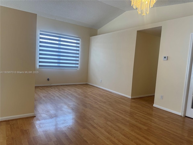 2383 SW 177th Ter, Miramar, FL 33029 - unfurnished room with a chandelier, wood finished floors, lofted ceiling, and a textured ceiling