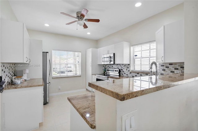 831 SW 178th Way, Pembroke Pines, FL 33029 - kitchen with stainless steel appliances, a ceiling fan, backsplash, white cabinets, and light tile patterned floors