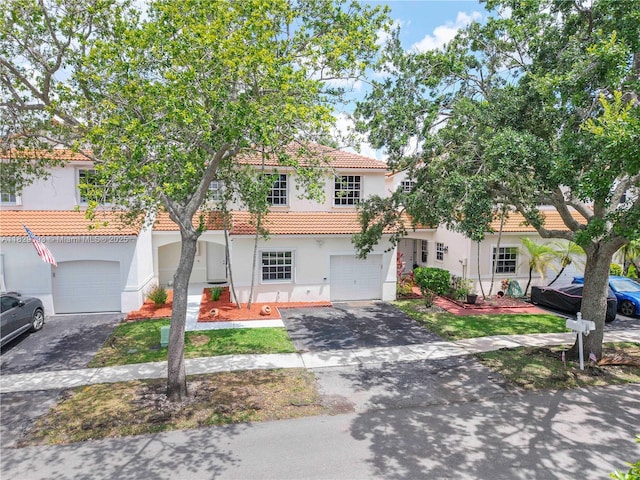 831 SW 178th Way, Pembroke Pines, FL 33029 - view of front of home with an attached garage, asphalt driveway, a tile roof, and stucco siding