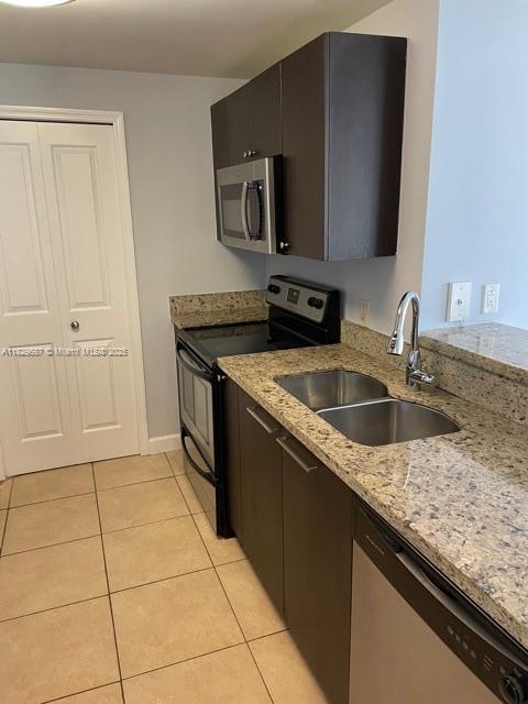2650 SW 37th Ave Unit 501, Miami, FL 33133 - kitchen featuring appliances with stainless steel finishes, light tile patterned floors, and light stone countertops