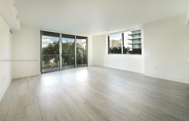 121 NE 34th St Unit 1009, Miami, FL 33137 - empty room with wood finished floors and expansive windows