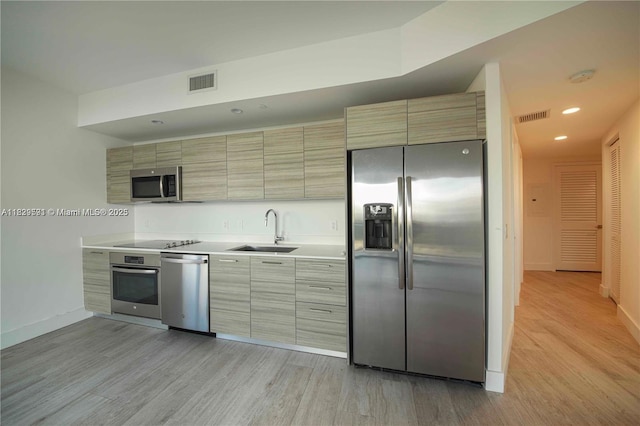 121 NE 34th St Unit 1009, Miami, FL 33137 - kitchen with stainless steel appliances, light wood-style flooring, light countertops, modern cabinets, and recessed lighting