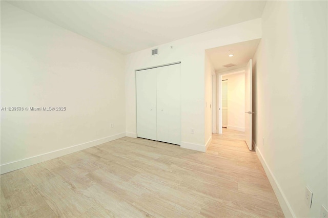 121 NE 34th St Unit 1009, Miami, FL 33137 - unfurnished bedroom featuring light wood-style flooring and a closet