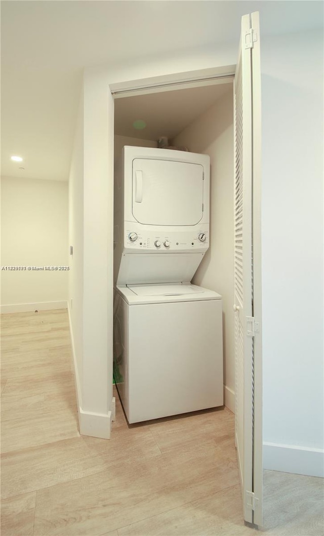 121 NE 34th St Unit 1009, Miami, FL 33137 - washroom with stacked washer / dryer and light wood-type flooring