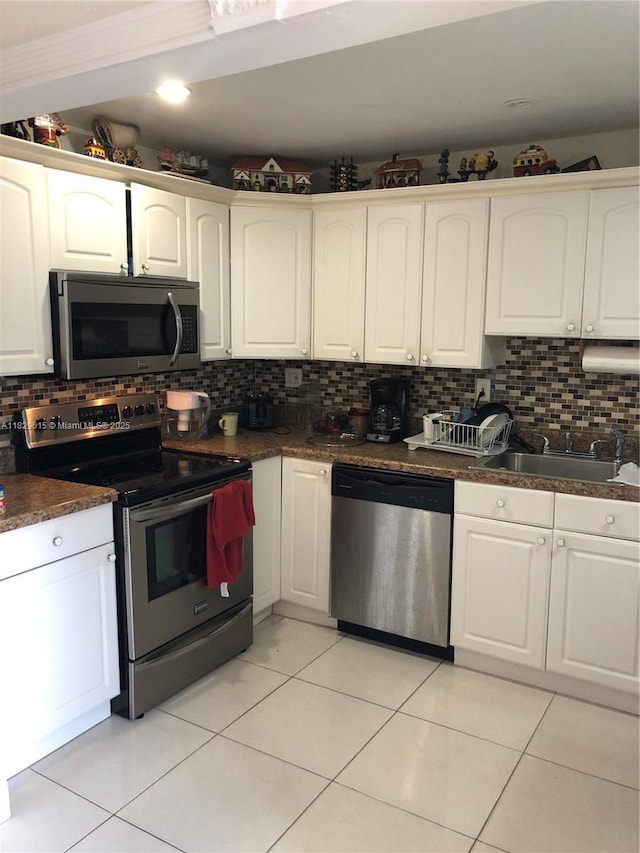 1475 NE 125th Ter Unit 301A, North Miami, FL 33161 - kitchen with stainless steel appliances, dark countertops, tasteful backsplash, and white cabinetry