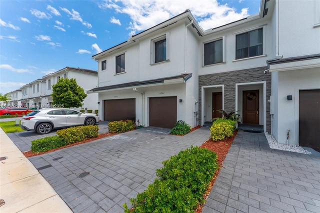 10962 SW 235, Homestead, FL 33032 - townhome / multi-family property featuring stucco siding, an attached garage, stone siding, and decorative driveway