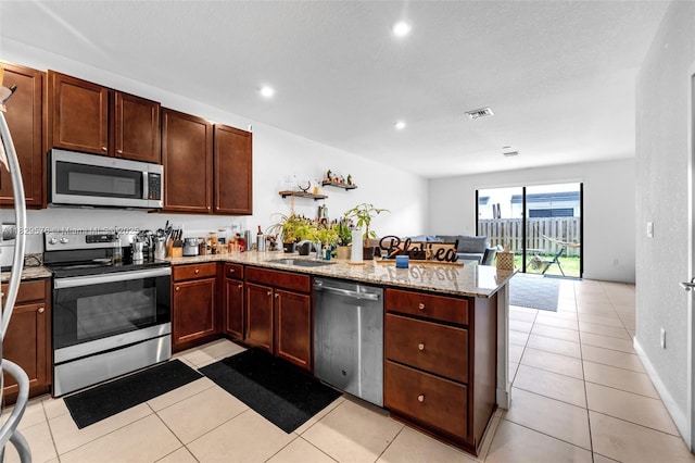 10962 SW 235, Homestead, FL 33032 - kitchen featuring stainless steel appliances, a peninsula, light stone countertops, light tile patterned flooring, and recessed lighting