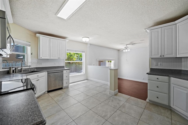 960 NW 185th Ave, Pembroke Pines, FL 33029 - kitchen with appliances with stainless steel finishes, dark countertops, a ceiling fan, light tile patterned flooring, and a textured ceiling