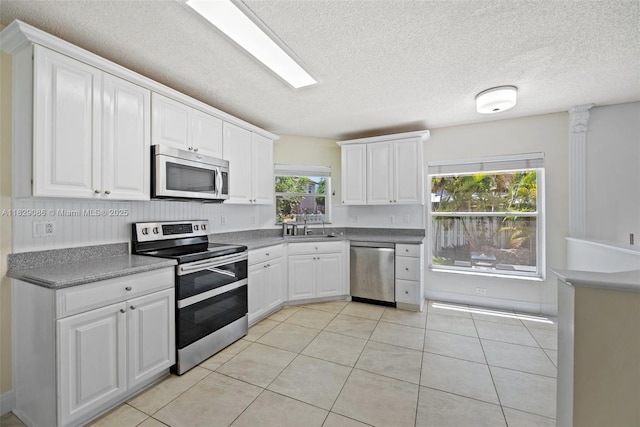 960 NW 185th Ave, Pembroke Pines, FL 33029 - kitchen with appliances with stainless steel finishes, light tile patterned floors, white cabinets, and a textured ceiling