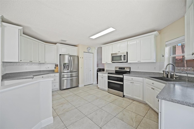 960 NW 185th Ave, Pembroke Pines, FL 33029 - kitchen featuring appliances with stainless steel finishes, white cabinetry, light tile patterned floors, and a textured ceiling