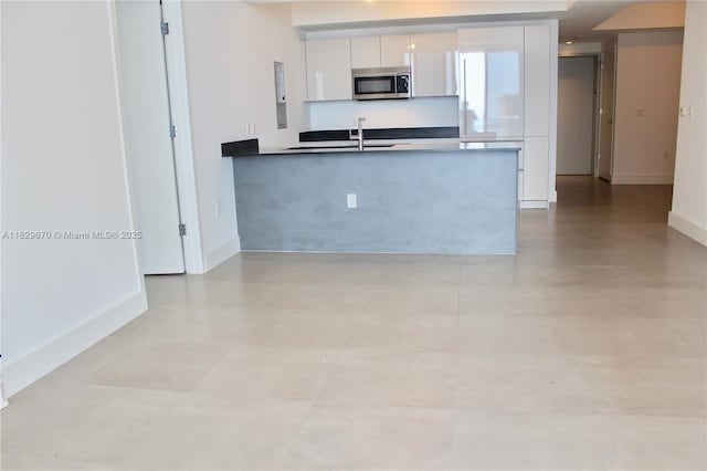 1010 Brickell Ave Unit 3403, Miami, FL 33131 - kitchen featuring stainless steel microwave, modern cabinets, white cabinets, and a peninsula
