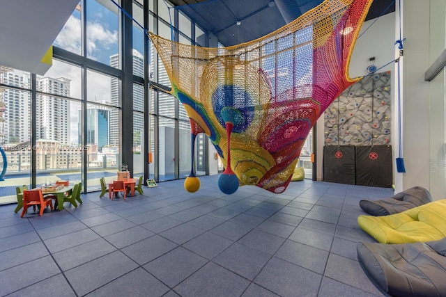 1010 Brickell Ave Unit 3403, Miami, FL 33131 - recreation room with a high ceiling, tile patterned floors, floor to ceiling windows, healthy amount of natural light, and a city view