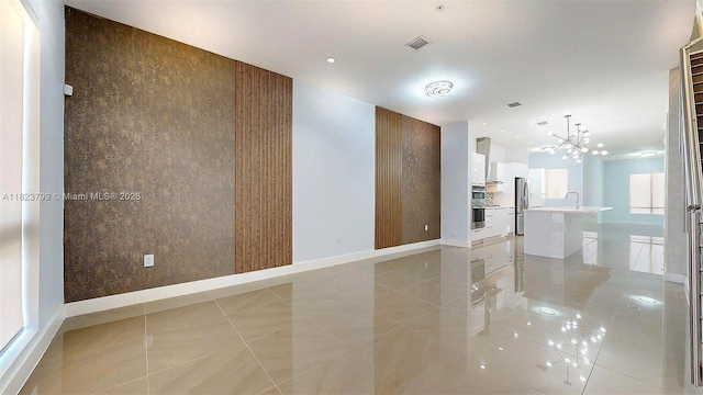 10255 NW 63rd Ter Unit 204, Doral, FL 33178 - unfurnished room with a chandelier, recessed lighting, an accent wall, and light tile patterned floors
