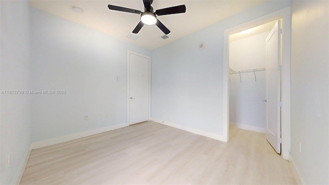 10255 NW 63rd Ter Unit 204, Doral, FL 33178 - unfurnished bedroom with light wood-style flooring, a closet, a ceiling fan, and a walk in closet