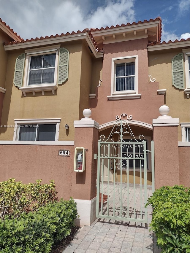 654 SW 106th Ave Unit 1502, Pembroke Pines, FL 33025 - view of front facade featuring a tile roof, a fenced front yard, stucco siding, and a gate