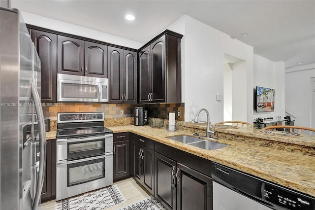 11898 SW 25th Ct Unit 103, Miramar, FL 33025 - kitchen featuring stainless steel appliances, light stone counters, tasteful backsplash, and light tile patterned floors