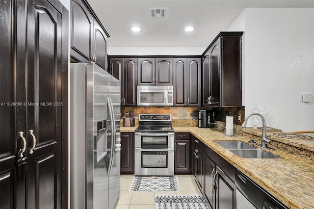 11898 SW 25th Ct Unit 103, Miramar, FL 33025 - kitchen with stainless steel appliances, light stone counters, light tile patterned flooring, tasteful backsplash, and recessed lighting