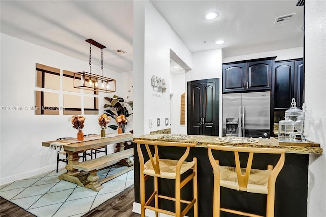 11898 SW 25th Ct Unit 103, Miramar, FL 33025 - kitchen featuring stainless steel refrigerator with ice dispenser, wood finished floors, a peninsula, recessed lighting, and a kitchen breakfast bar