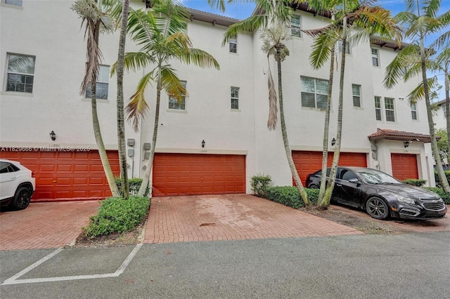 11898 SW 25th Ct Unit 103, Miramar, FL 33025 - view of front of home featuring stucco siding, a garage, and driveway