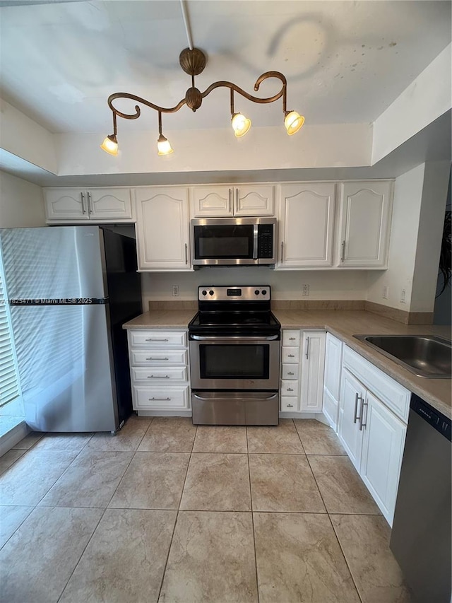 2371 SW 15th St Unit 101, Deerfield Beach, FL 33442 - kitchen with stainless steel appliances, white cabinets, light countertops, and light tile patterned flooring