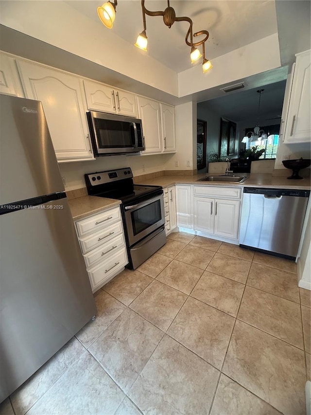 2371 SW 15th St Unit 101, Deerfield Beach, FL 33442 - kitchen featuring appliances with stainless steel finishes, white cabinetry, and light tile patterned flooring
