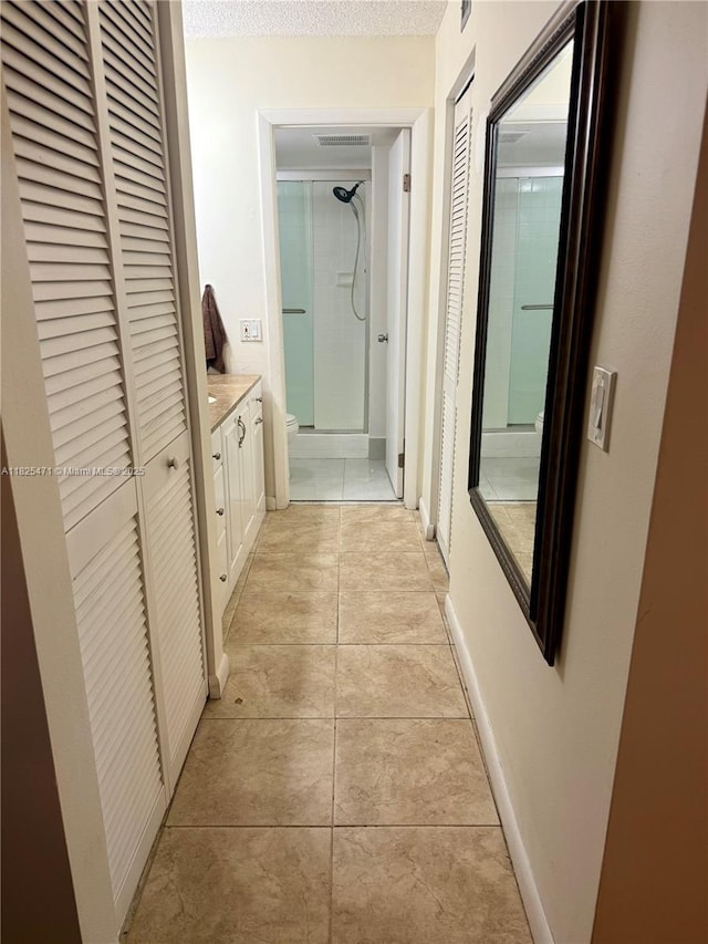 2371 SW 15th St Unit 101, Deerfield Beach, FL 33442 - corridor with light tile patterned floors and a textured ceiling