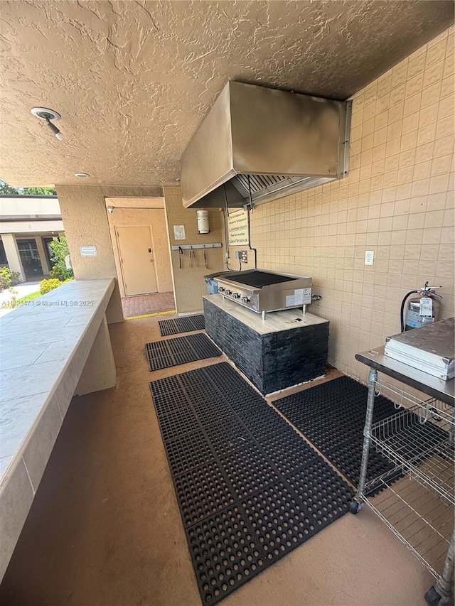 2371 SW 15th St Unit 101, Deerfield Beach, FL 33442 - misc room featuring a textured ceiling, finished concrete flooring, and tile walls