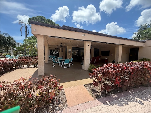 2371 SW 15th St Unit 101, Deerfield Beach, FL 33442 - rear view of property featuring stucco siding, a patio, outdoor dining area, and ceiling fan