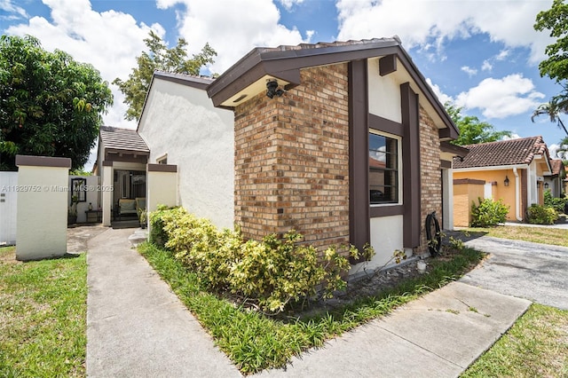 17625 NW 62nd Ct, Hialeah, FL 33015 - view of side of property featuring stucco siding, brick siding, and a tile roof
