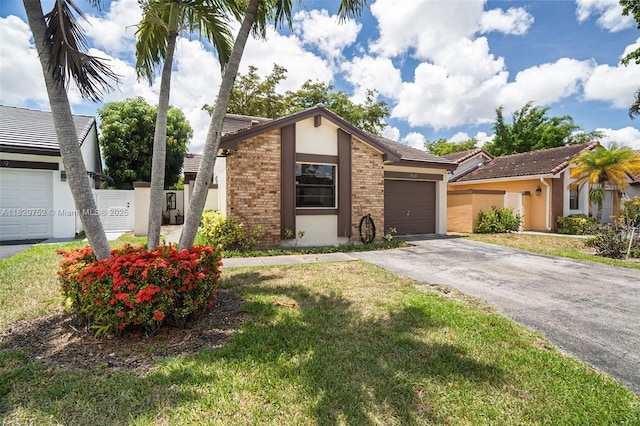 17625 NW 62nd Ct, Hialeah, FL 33015 - view of front facade featuring stucco siding, asphalt driveway, an attached garage, a front lawn, and brick siding