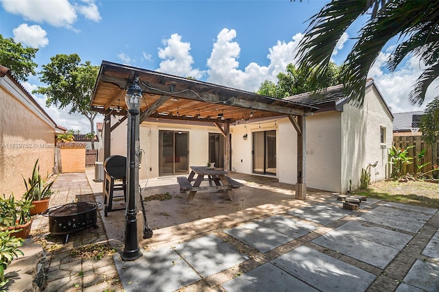 17625 NW 62nd Ct, Hialeah, FL 33015 - rear view of house with stucco siding, a fire pit, a fenced backyard, and a patio