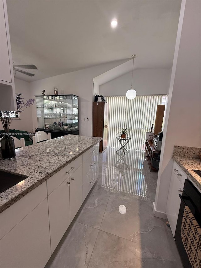 7440 SW 153rd Ct Unit 107-4, Miami, FL 33193 - kitchen featuring oven, light marble finish flooring, white cabinets, light stone counters, and vaulted ceiling
