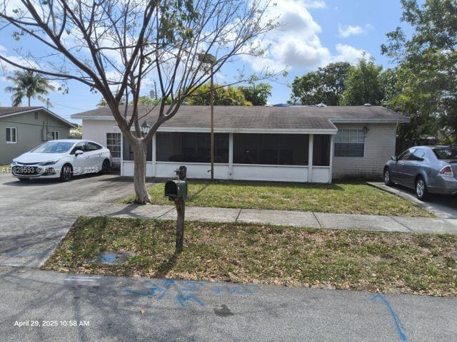 1484 SW 47th Ter, Fort Lauderdale, FL 33317 - ranch-style home featuring a sunroom, a front lawn, a shingled roof, and driveway