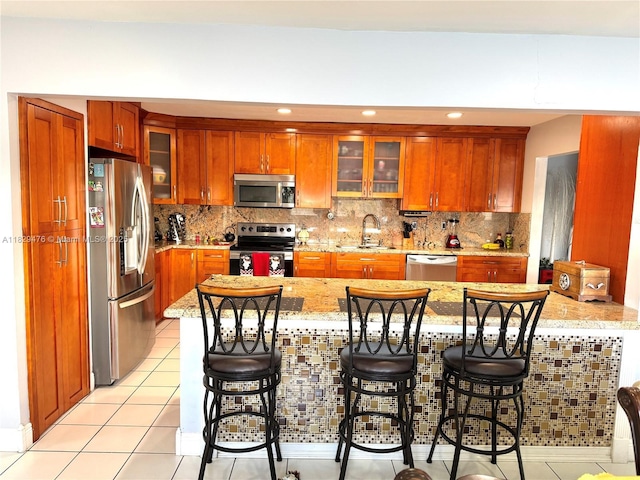 13261 SW 17th Ln, Miami, FL 33175 - kitchen featuring stainless steel appliances, light stone counters, tasteful backsplash, a peninsula, and glass insert cabinets