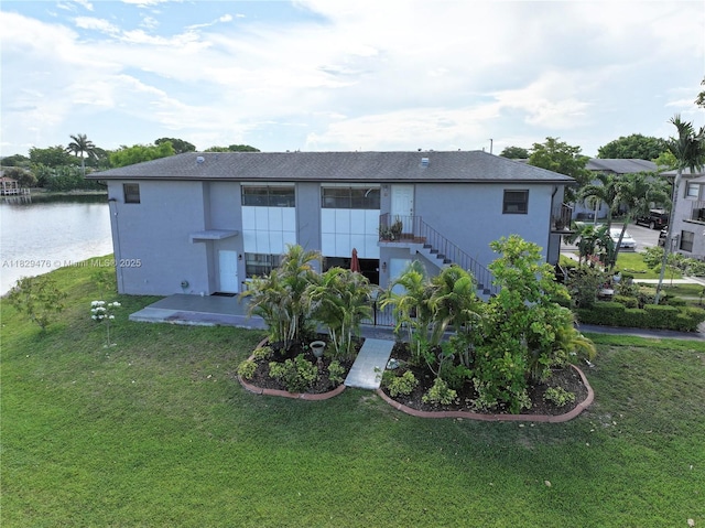 13261 SW 17th Ln, Miami, FL 33175 - rear view of house with stucco siding, a lawn, a water view, and stairs