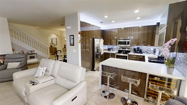 4231 SW 165th Ct, Miami, FL 33185 - kitchen with stainless steel appliances, open floor plan, dark brown cabinetry, light tile patterned floors, and tasteful backsplash