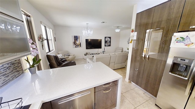 4231 SW 165th Ct, Miami, FL 33185 - kitchen with stainless steel fridge with ice dispenser, open floor plan, a chandelier, light tile patterned floors, and modern cabinets