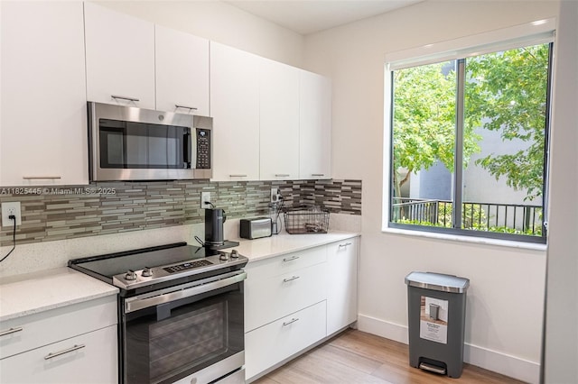 4269 NW 83rd Path, Doral, FL 33166 - kitchen featuring stainless steel appliances, decorative backsplash, light wood finished floors, and white cabinets