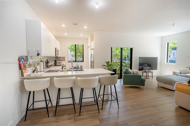 4269 NW 83rd Path, Doral, FL 33166 - kitchen featuring stainless steel appliances, a peninsula, a kitchen bar, light countertops, and light wood-style flooring