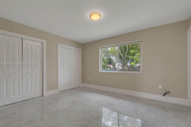 9241 SW 204th Ter, Cutler Bay, FL 33189 - unfurnished bedroom with two closets and marble look tiles