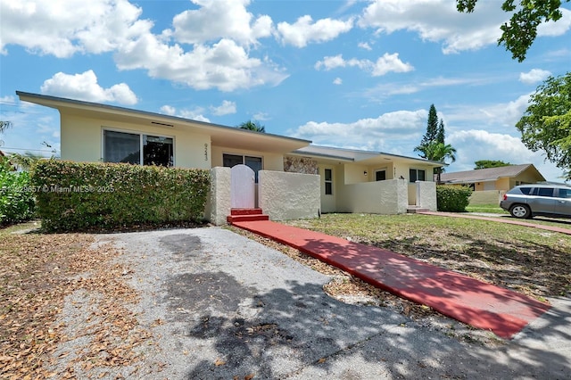 9241 SW 204th Ter, Cutler Bay, FL 33189 - view of front facade featuring stucco siding, a fenced front yard, and a gate