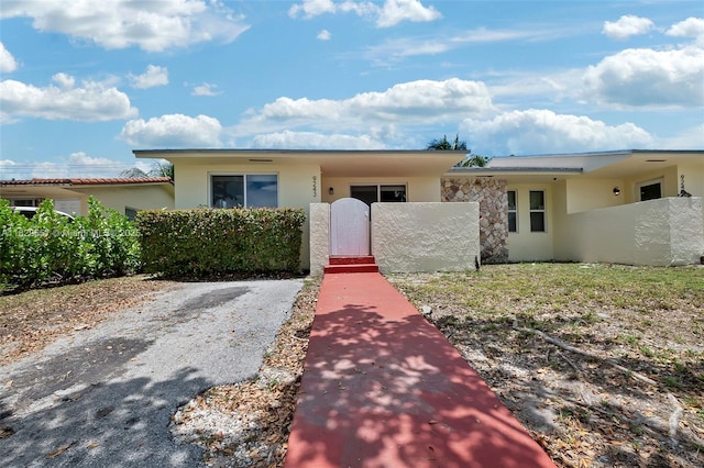 9241 SW 204th Ter, Cutler Bay, FL 33189 - view of front of home with a fenced front yard, stucco siding, and a gate