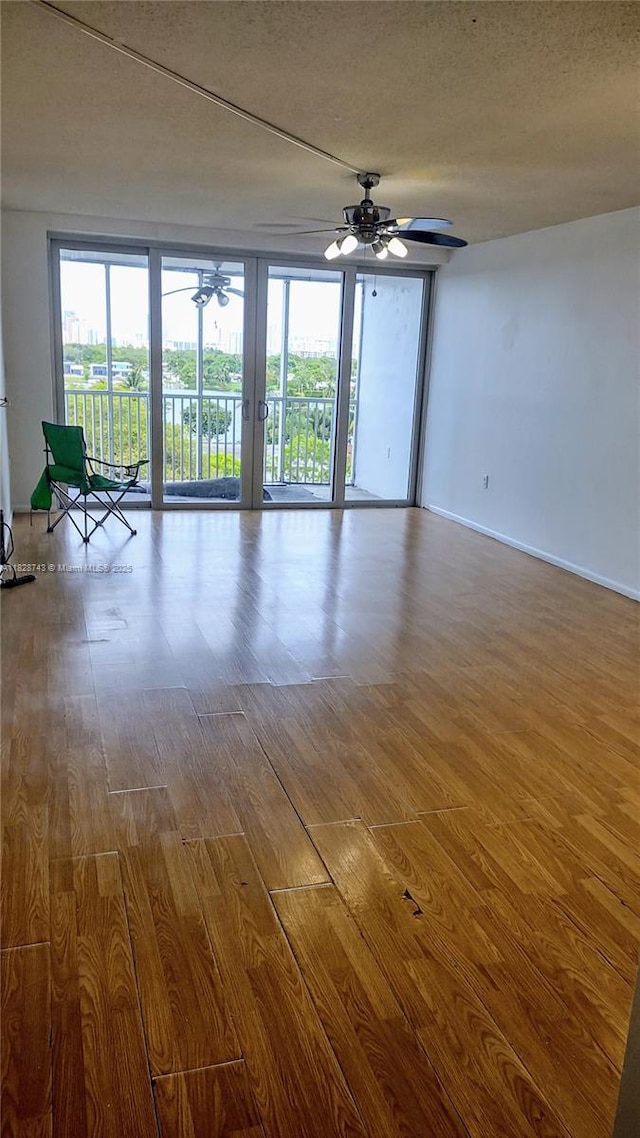 1780 NE 191st St Unit 704-2, Miami, FL 33179 - unfurnished room with ceiling fan, wood finished floors, plenty of natural light, and a textured ceiling