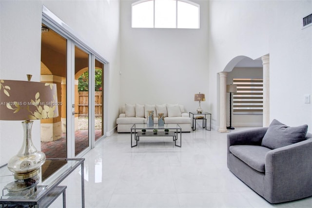 15445 SW 26th Ter, Miami, FL 33185 - living area with ornate columns, a towering ceiling, arched walkways, and light tile patterned floors