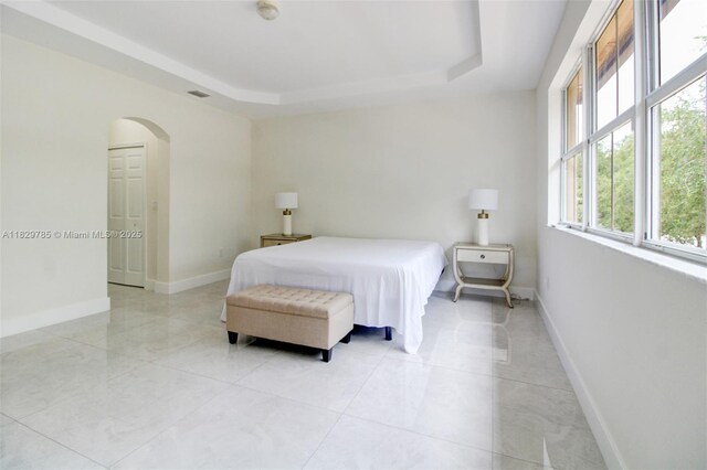 15445 SW 26th Ter, Miami, FL 33185 - bedroom with arched walkways, a raised ceiling, and light tile patterned floors